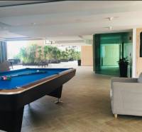 Interior space with a pool table and a sofa within the construction of apartments.