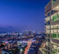 Night panorama of Pattaya with city lights and apartment construction in the foreground.