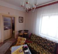 A room with a vintage sofa, furniture, and curtains in a family house.