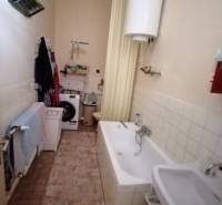 Bathroom in a family house with a bathtub, sink, and washing machine.