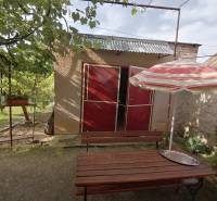 A garden by a family house in Hrkovce with a table and an umbrella.