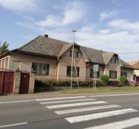 A family house in Hrkovce by the road, tiled roof, closed red gates.