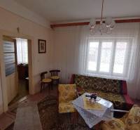 Living room in a family house with retro furniture, patterned curtains, and soft lighting.