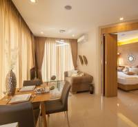 Living room and dining area with access to the bedroom in a 2-room apartment.