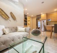Stylish interior of a 2-room apartment with a comfortable sofa and modern kitchen equipment.