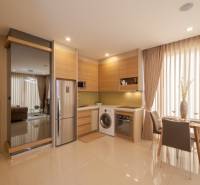 Kitchen corner in a 2-room apartment, with a dining table, refrigerator, and washing machine.