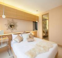 Bright bedroom in a 2-room apartment with a decorative mirror above the bed.