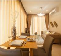 Dining room in a 2-room apartment with wooden furniture and hanging curtains.