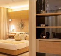 A bedroom in a 2-room apartment with wooden details and a comfortable bed.