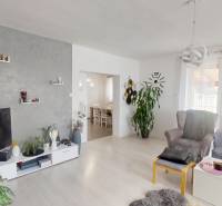 Living room in a family house with a sofa, armchair, television, and wall decorations.