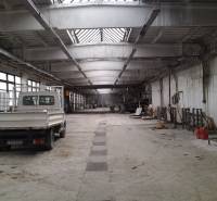 A spacious hall with a parked car and storage tanks in Levice.