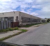 Warehouses and halls in Levice with neglected surroundings on a side street.