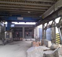Industrial interior of warehouses and halls with large stone blocks and a crane.