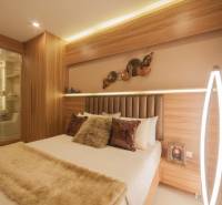 A bedroom in a 3-room apartment with a mirror, wooden elements, and soft lighting.