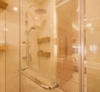 Shower corner with wooden shelves in a 3-room apartment, decorated with a real estate agency's verification mark.