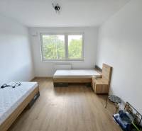 A room with two beds and a window, wooden floor in a 3-room apartment.