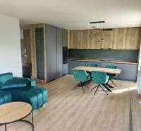 Living room in a 3-room apartment with wooden flooring and a green sofa.