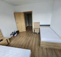 A bedroom with two single beds and wooden flooring, 3-room apartment.
