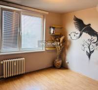 A room with a wall mural and wooden floor in a 3-room apartment, bright walls.