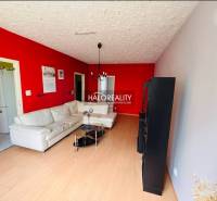 Living room in a three-room apartment with a light sofa and a red wall.