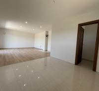Interior of a family house with parquet and tiled flooring, wooden doors, white walls.