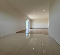 A spacious room in a family house with ceramic and wooden flooring.