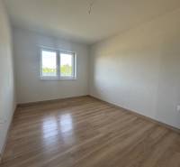 An empty room with a wooden floor and a window in a family house.