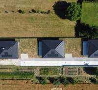 An aerial view of three family houses in Podlužany with solar panels on the roofs.