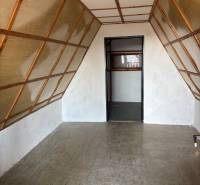 An attic room with wooden and white walls in recreational grounds.