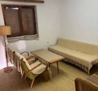 A simple interior with retro furniture, a sofa, armchairs, and a wooden coffee table.