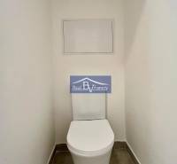 Toilet in a 2-room apartment with white walls and ceramic tiles.