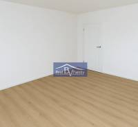 A spacious empty room with wooden flooring in a 2-room apartment.