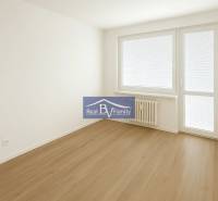 Bright room with wooden flooring and balcony doors in a 2-room apartment.