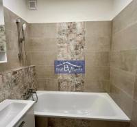 Bathroom with a bathtub and a shower head in a 2-room apartment.