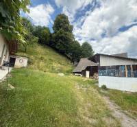 The yard of a rural family house in Záriečie on Záriečie with a grassy area and a shelter.