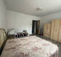 Bedroom in a family house with a large wardrobe and a double bed in light colors.