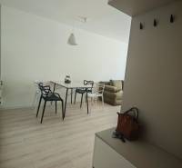 Interior of a 1-room apartment with light furniture and wooden flooring, includes a dining table.