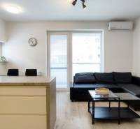 Living room in a two-room apartment with a sofa, table, and access to the balcony.
