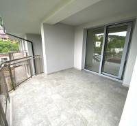 A balcony in a 2-room apartment in Rajecké Teplice with a view of greenery and surrounding buildings.