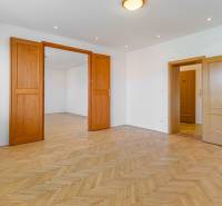 A room with a parquet floor and wooden doors in a family house.