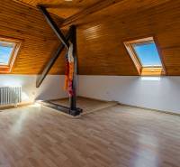 Attic room with skylights and wooden paneling in a family house.