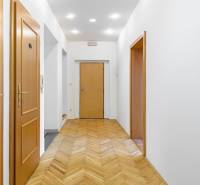 A hallway in a family house with wooden doors and parquet flooring.