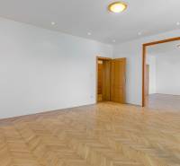 A spacious room with white walls and a parquet floor in a family house.