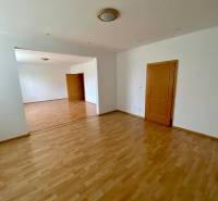 Spacious room with wooden floor and two doors in a family house.