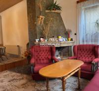Living room in a family house with a fireplace and red armchairs.