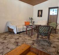 Living room in a family house with a sofa, chairs, and a carpet.