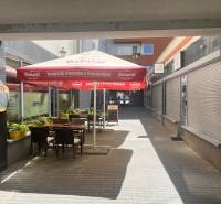 A café with tables and an umbrella on Lichnerova Street in Senec.