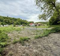 Land for housing in Selce with adjacent greenery and a view of houses in the background.