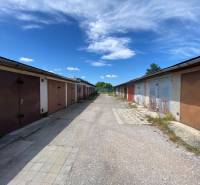 Row garages on Kolárska Street in Spišská Nová Ves on a sunny day.
