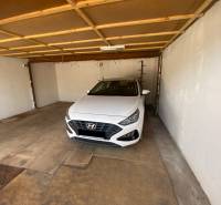 The interior of a garage with a white Hyundai car parked inside.